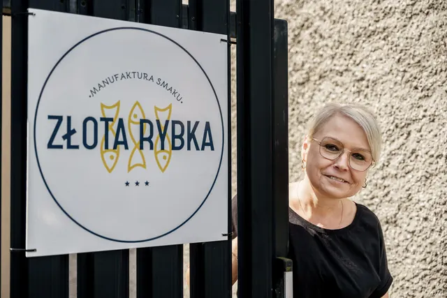 Tabliczka z logo Złotej Rybki na bramie przy ul. Słonecznej